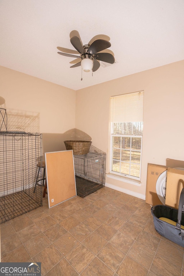 interior space with ceiling fan