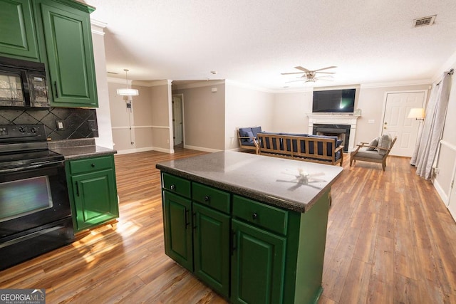 kitchen with light hardwood / wood-style floors, green cabinets, ceiling fan, and black appliances