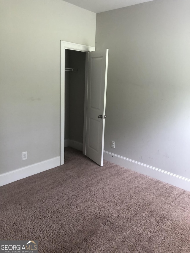 284 Madison Grace Ave, Mcdonough, GA 30252 - unfurnished bedroom with carpet flooring, baseboards, and a closet