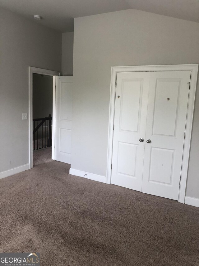 284 Madison Grace Ave, Mcdonough, GA 30252 - unfurnished bedroom featuring carpet flooring, vaulted ceiling, baseboards, and a closet