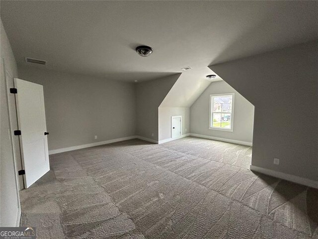 additional living space with vaulted ceiling and carpet floors
