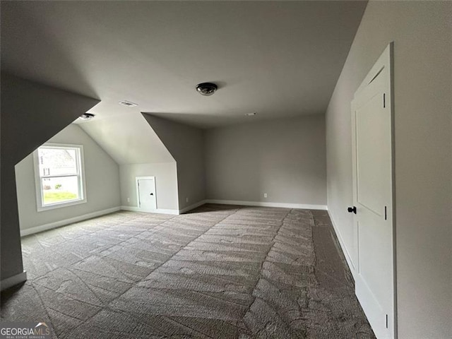 additional living space featuring lofted ceiling and carpet