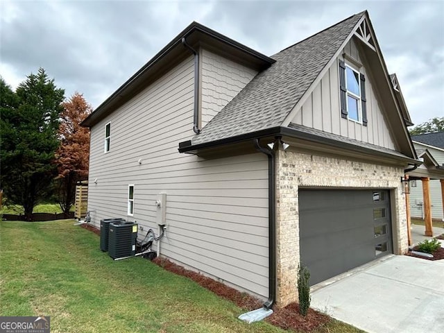 view of side of property with central AC, a garage, and a yard