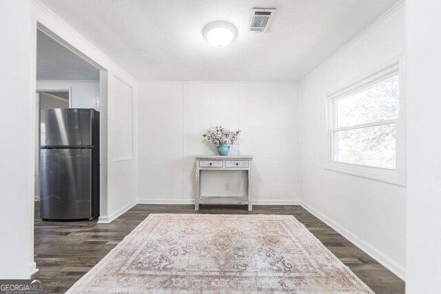 unfurnished room with crown molding and dark hardwood / wood-style flooring