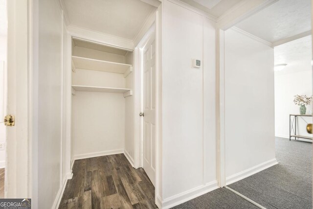 hallway with dark colored carpet