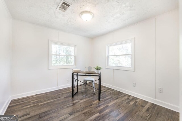 spare room with a healthy amount of sunlight and dark hardwood / wood-style floors