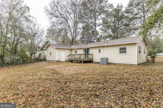 back of property with cooling unit, a deck, and a lawn