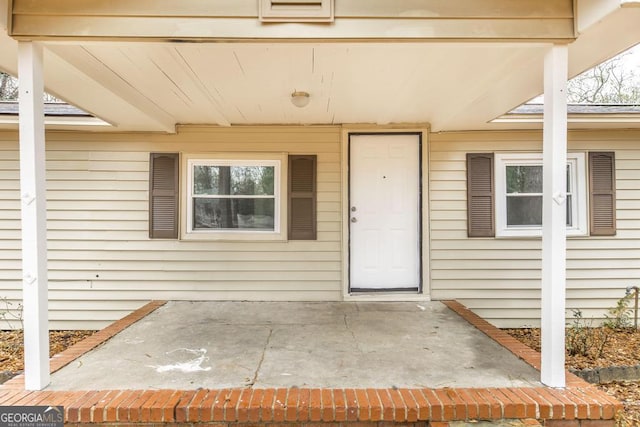 view of exterior entry featuring a patio