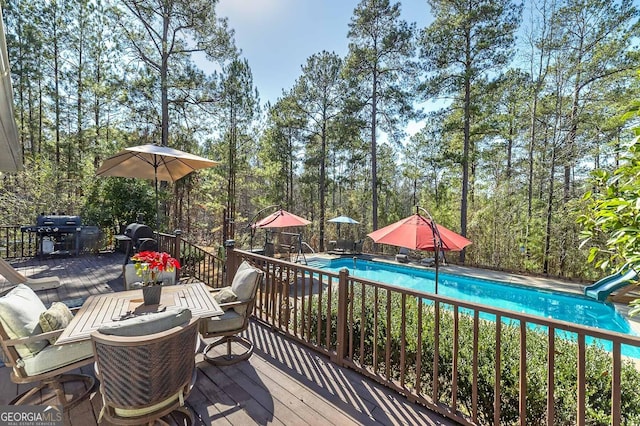 wooden deck with a grill and a fenced in pool