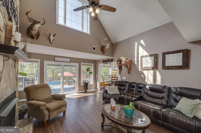 living room with hardwood / wood-style flooring, a high ceiling, a wealth of natural light, and ceiling fan