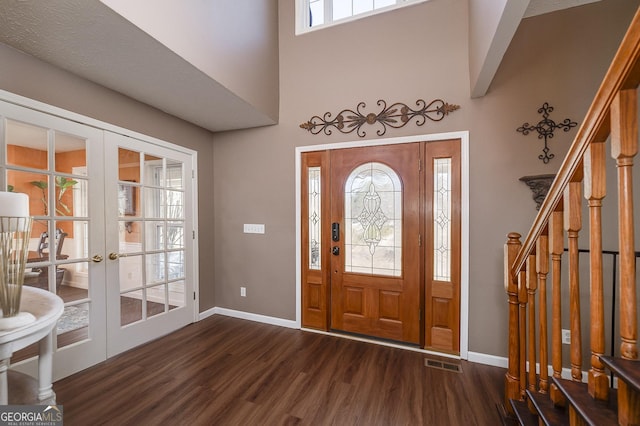 foyer entrance featuring a high ceiling, dark hardwood / wood-style floors, and french doors