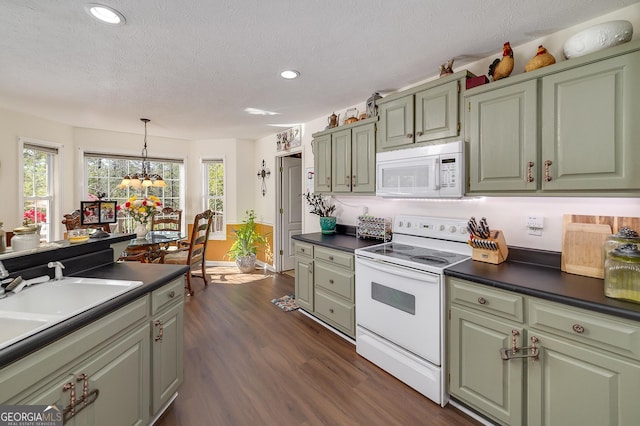 kitchen featuring dark hardwood / wood-style flooring, white appliances, a textured ceiling, and green cabinets