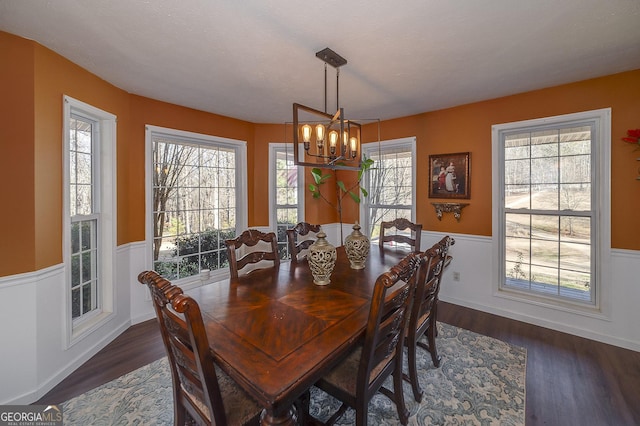 dining space with dark wood-type flooring, a textured ceiling, and a chandelier