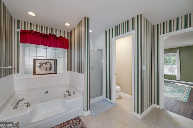 bathroom with tile patterned floors, toilet, and separate shower and tub