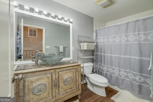 bathroom with wood-type flooring, toilet, and vanity