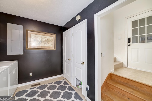 tiled entrance foyer featuring independent washer and dryer, electric panel, and a textured ceiling