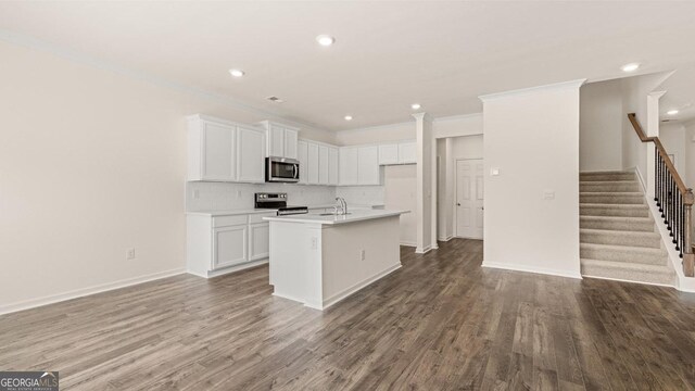 321 Sound Cir, Stockbridge, GA 30281 - kitchen featuring a center island with sink, hardwood / wood-style flooring, tasteful backsplash, stainless steel appliances, and white cabinets