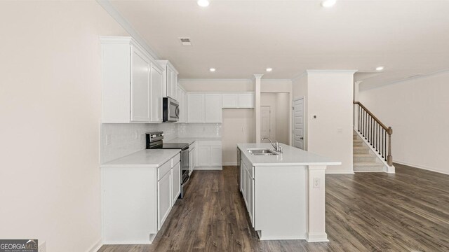 321 Sound Cir, Stockbridge, GA 30281 - kitchen featuring sink, white cabinetry, stainless steel appliances, dark wood-type flooring, and an island with sink
