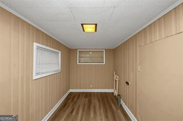 laundry area featuring ornamental molding and hardwood / wood-style floors