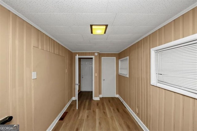 hallway featuring ornamental molding and light wood-type flooring