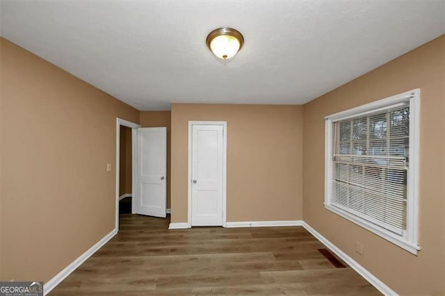 unfurnished bedroom featuring wood-type flooring and a closet