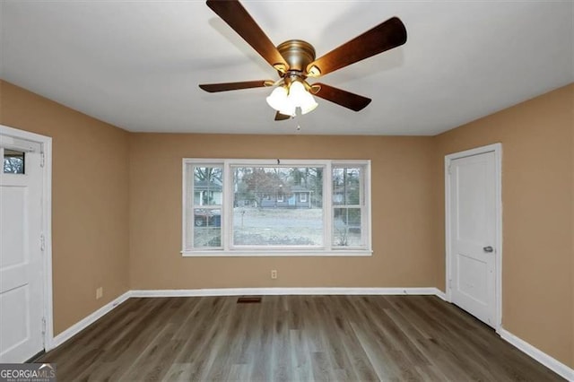 spare room with dark wood-type flooring and ceiling fan