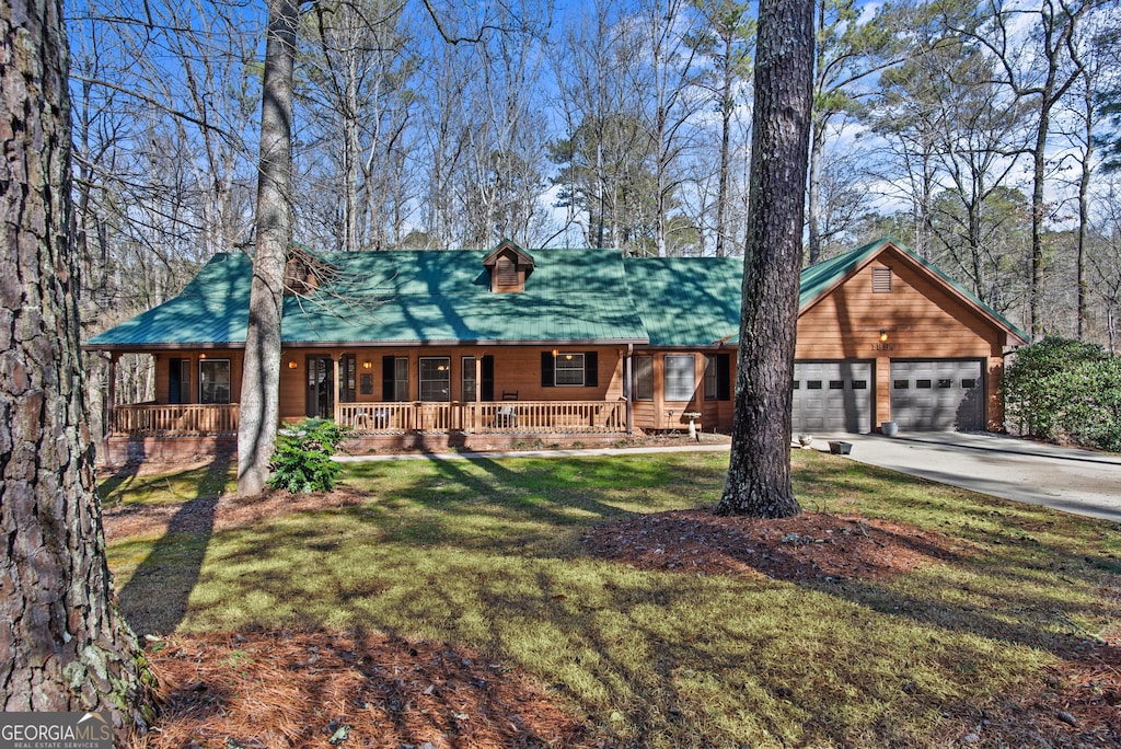 ranch-style house featuring a porch, a garage, and a front yard