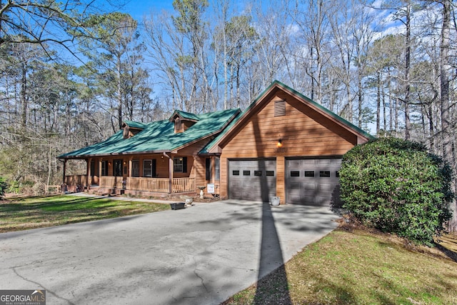 view of front of property featuring a porch, a garage, and a front yard