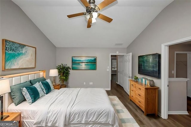 bedroom with ceiling fan, dark hardwood / wood-style floors, and vaulted ceiling