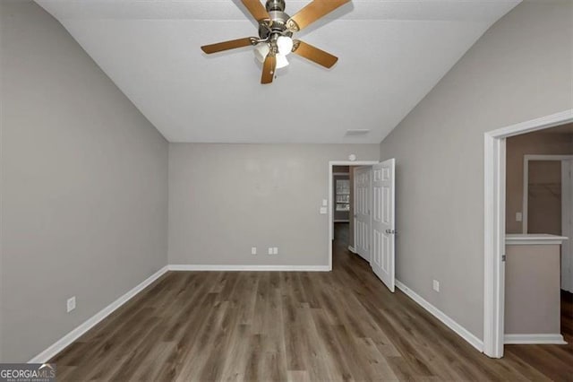 unfurnished bedroom featuring lofted ceiling, dark hardwood / wood-style floors, and ceiling fan