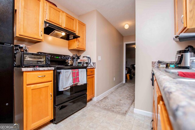 kitchen featuring black / electric stove and ventilation hood