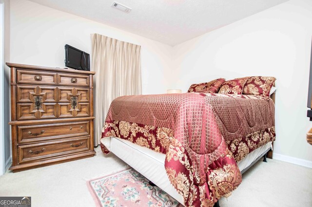 carpeted bedroom with a textured ceiling and a closet