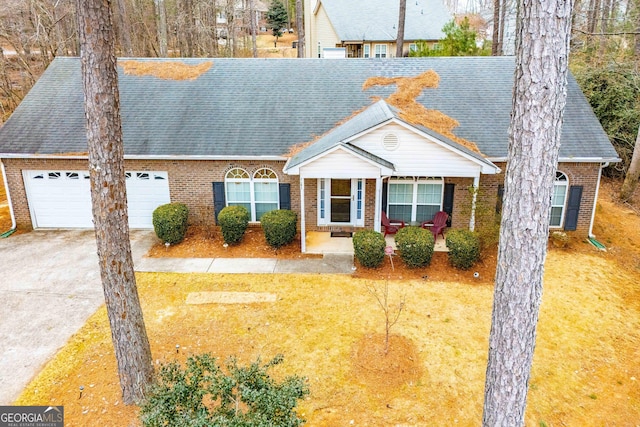 view of front of property with a porch, a garage, and a front lawn