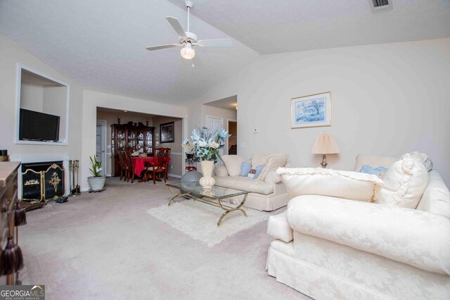 living room featuring lofted ceiling, carpet floors, and ceiling fan