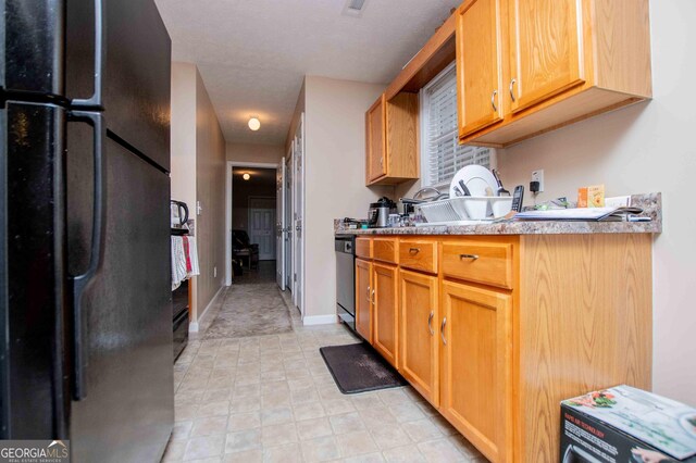 kitchen featuring black fridge and dishwashing machine