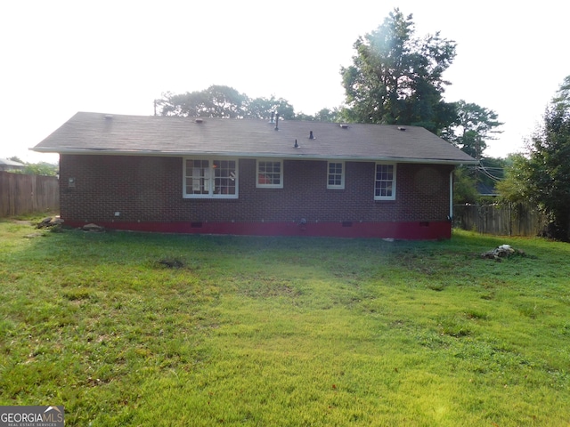 rear view of property featuring a lawn