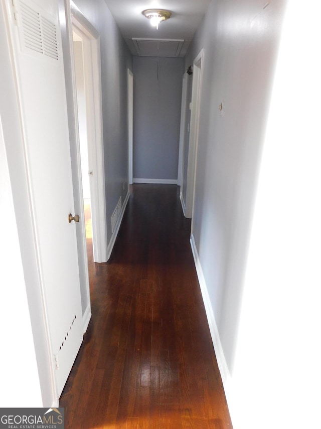 corridor with dark hardwood / wood-style flooring