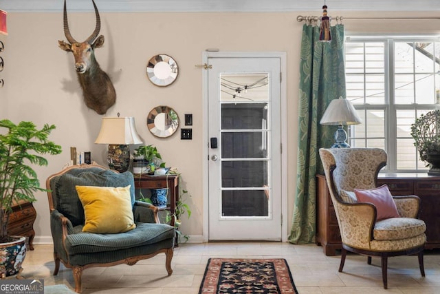 sitting room featuring crown molding and light tile patterned floors