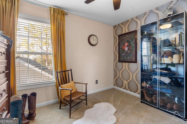 living area with light carpet and ceiling fan