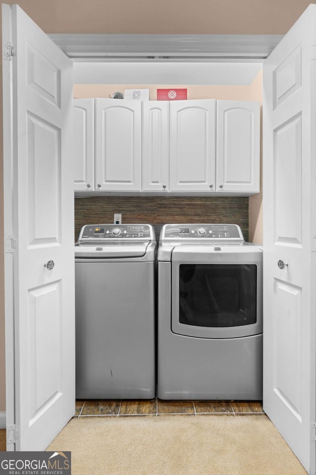 washroom featuring cabinets and independent washer and dryer