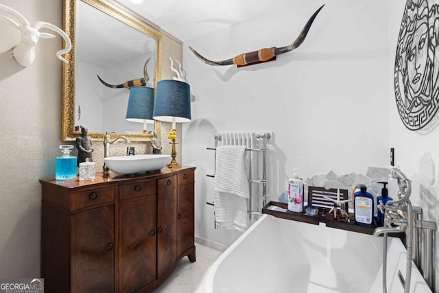 bathroom with radiator heating unit, a bath, and vanity