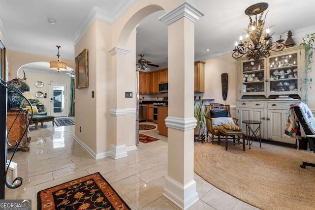 interior space with ceiling fan, ornamental molding, and decorative columns