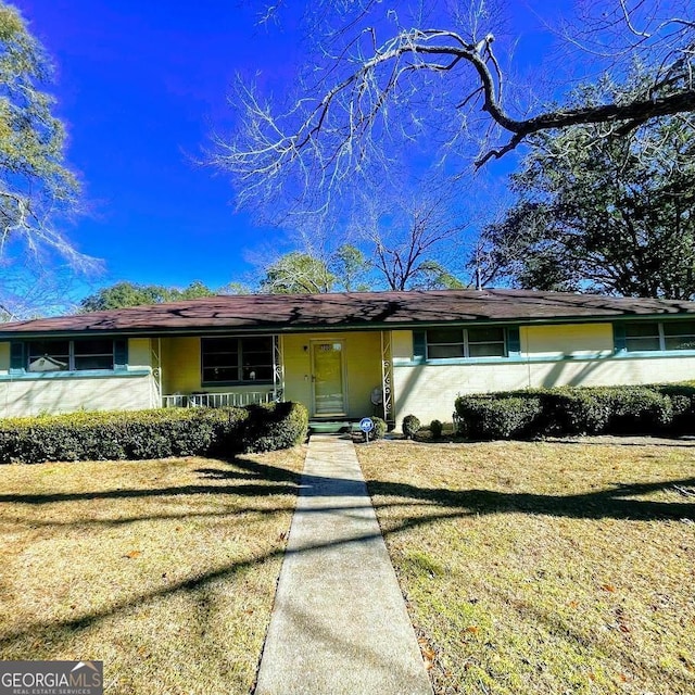 single story home with a front lawn