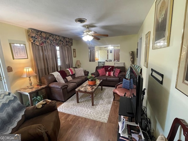 living room featuring ceiling fan and dark hardwood / wood-style flooring