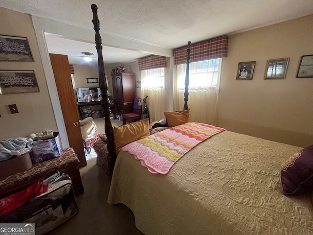 bedroom with carpet floors and a textured ceiling