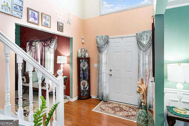 entryway featuring hardwood / wood-style flooring and a high ceiling