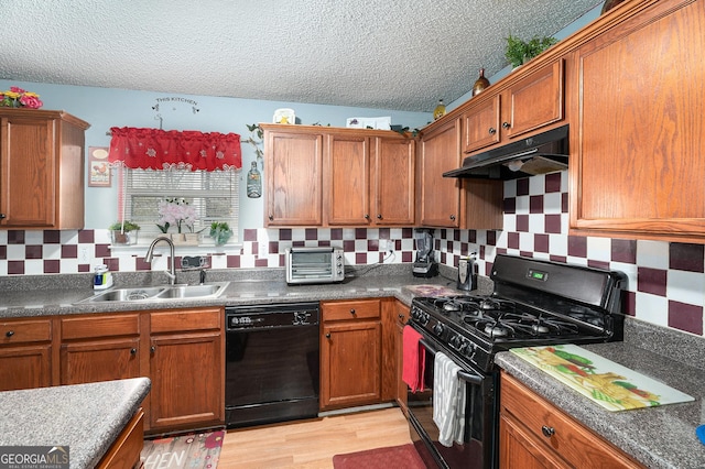 kitchen featuring sink, black appliances, a textured ceiling, light wood-type flooring, and backsplash