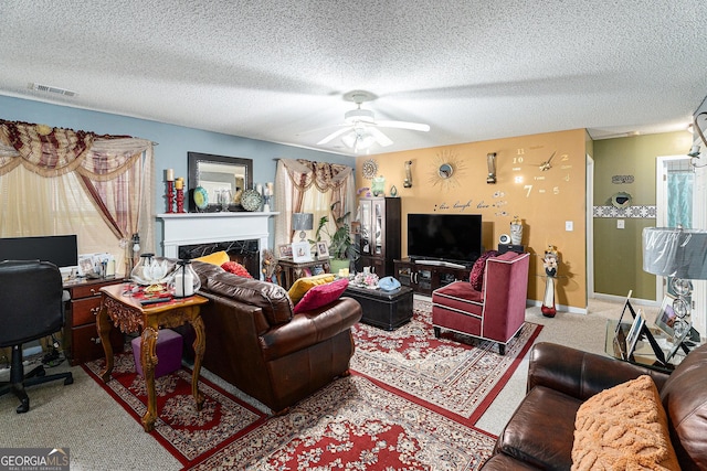 living room with ceiling fan, a high end fireplace, carpet floors, and a textured ceiling