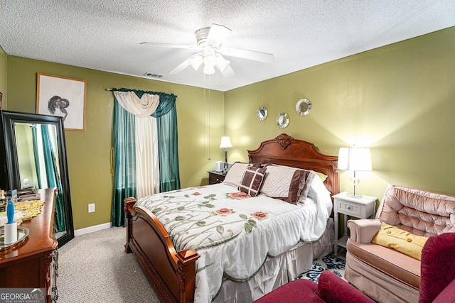 carpeted bedroom with ceiling fan and a textured ceiling