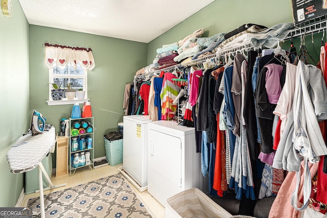 washroom with light tile patterned floors, a textured ceiling, and washer and clothes dryer